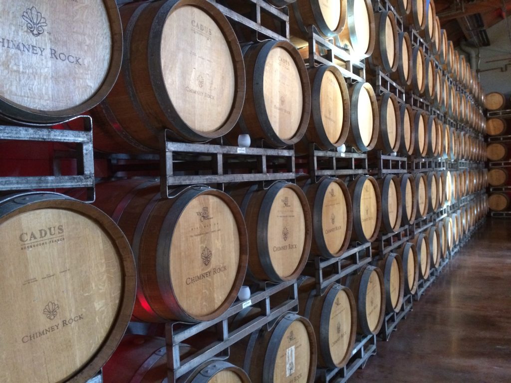 Wall of wine barrels in a winery cellar